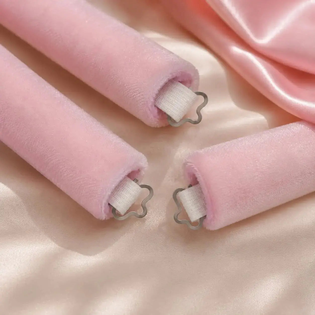 Close-up of pink velvet heatless hair rollers designed to reduce slipping
