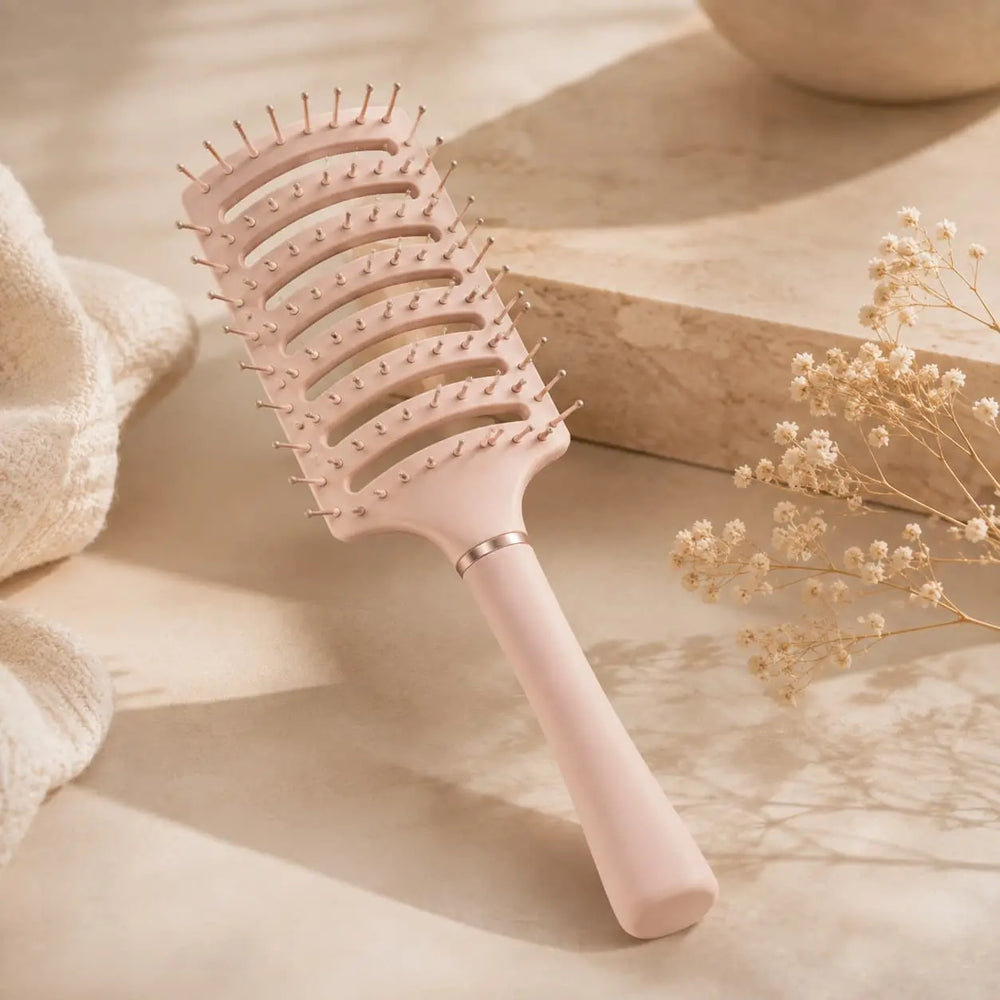 Pale pink anti-static vent brush displayed on a soft neutral background for gentle detangling and faster blow-drying.