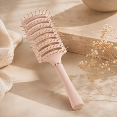 Pale pink anti-static vent brush displayed on a soft neutral background for gentle detangling and faster blow-drying.
