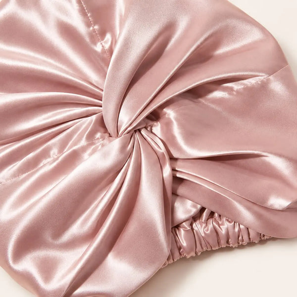 Close-up of a blush pink mulberry silk bonnet and its smooth silk finish