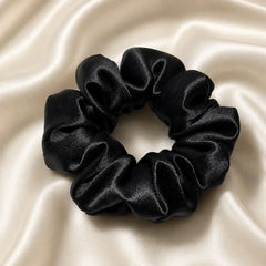Black 30 momme 6A silk scrunchie on an ivory silk background