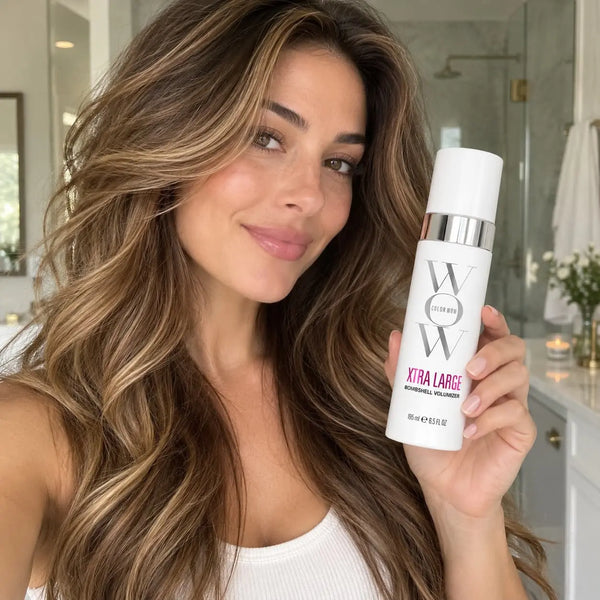 Woman holding Color Wow Xtra Large Bombshell Volumizer with voluminous hair