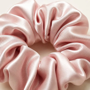Close-up of a pink 30 momme 6A silk scrunchie showing its smooth texture and soft folds