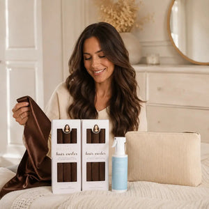 Woman holding a brown satin scarf beside Revitalysse brown heatless curlers, hair mist and corduroy pouch