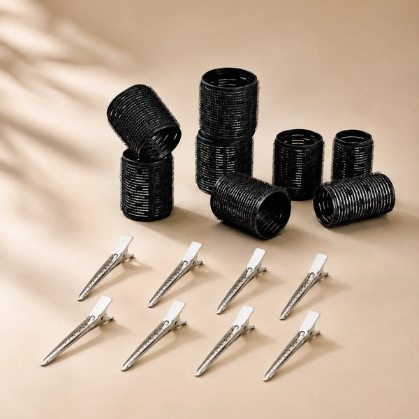 Black volume hair rollers with metal clips arranged on a neutral background for creating root lift and blowout-style volume.