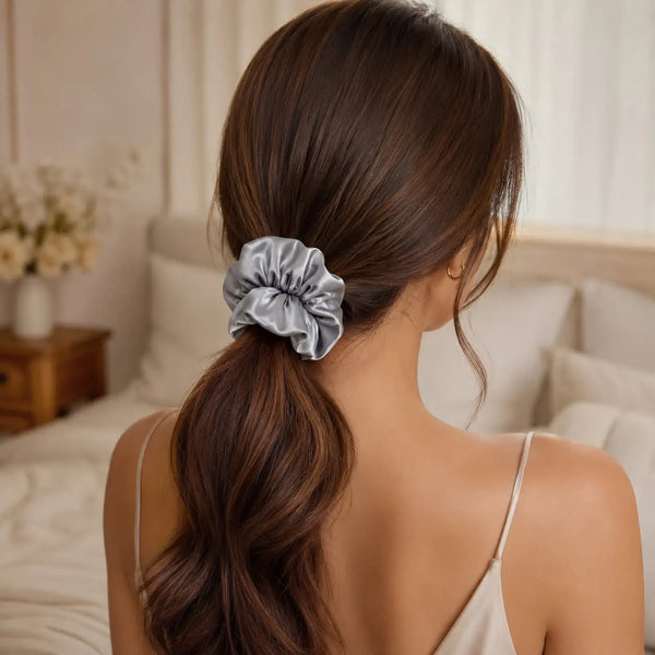 Woman wearing a silver 30 momme 6A silk scrunchie in a loose low ponytail
