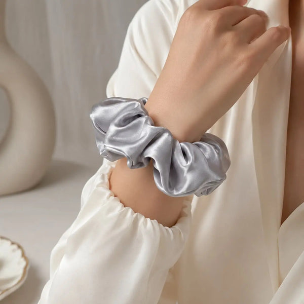 Woman wearing a silver 30 momme 6A silk scrunchie around her wrist